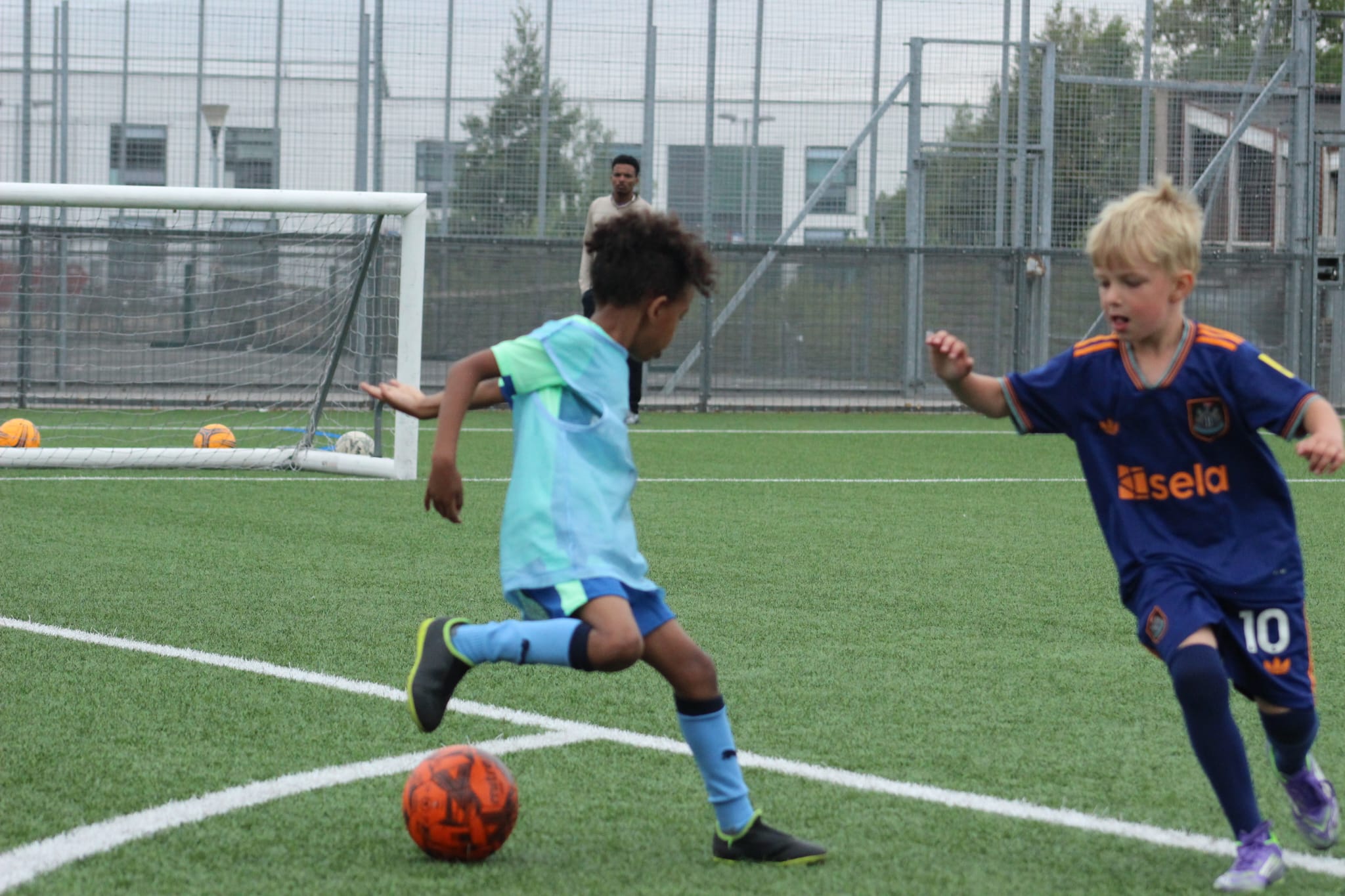 Players being watched by football scouts during a trial